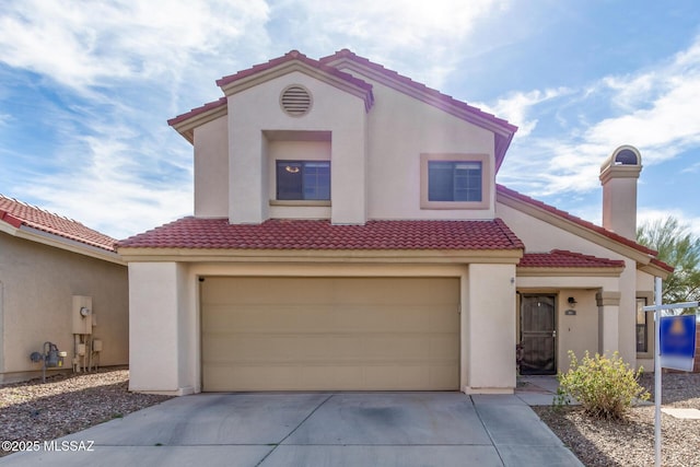 mediterranean / spanish-style home with an attached garage, a tile roof, concrete driveway, stucco siding, and a chimney