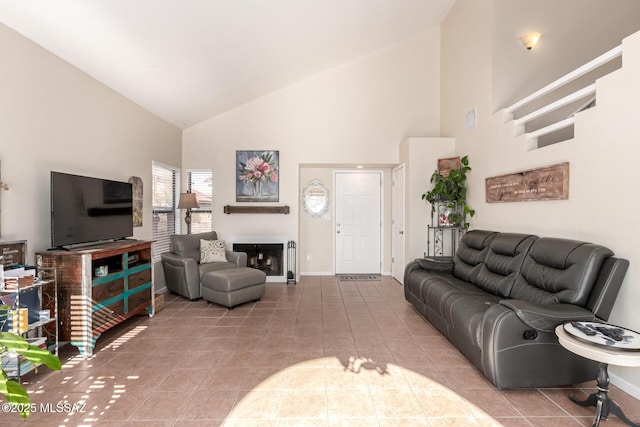 living room featuring high vaulted ceiling, a fireplace, baseboards, and tile patterned floors