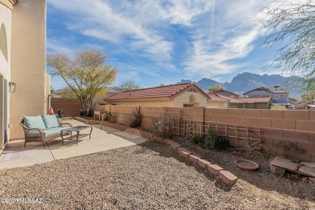 view of yard with a fenced backyard, a mountain view, an outdoor hangout area, and a patio