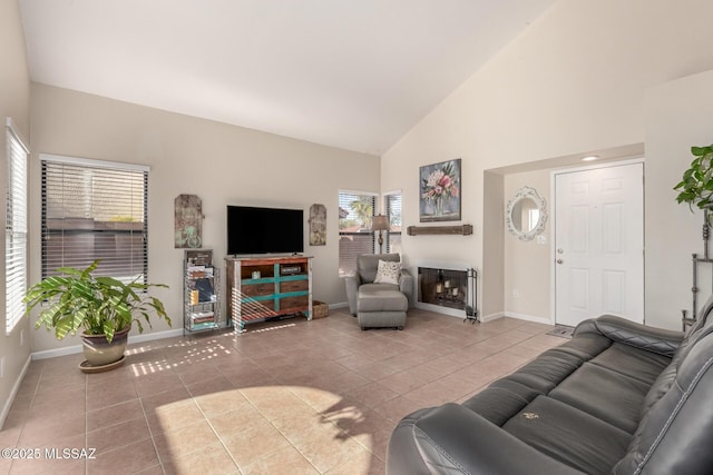 living room featuring high vaulted ceiling, a fireplace, tile patterned flooring, and baseboards