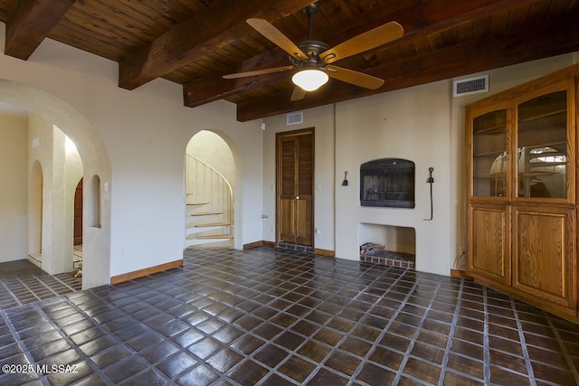 unfurnished living room with dark tile patterned floors, ceiling fan, wood ceiling, and beam ceiling