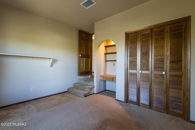 unfurnished bedroom with light carpet and a closet