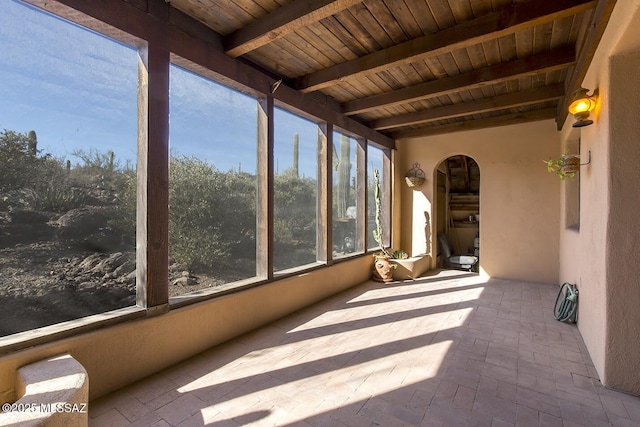 unfurnished sunroom with beamed ceiling and wooden ceiling