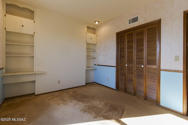 unfurnished bedroom with a closet and carpet flooring