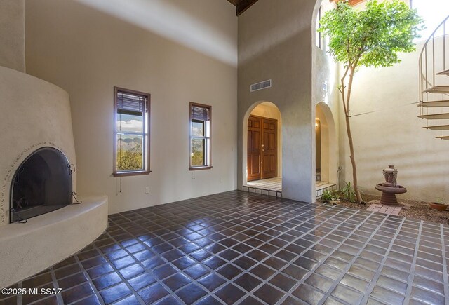 unfurnished living room with wood ceiling, ceiling fan, dark tile patterned floors, and beamed ceiling