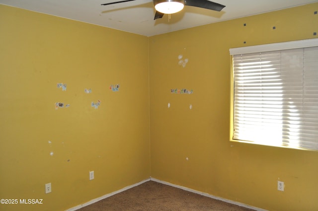 unfurnished room featuring carpet floors, a ceiling fan, and baseboards