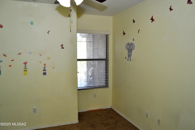 unfurnished room featuring a wealth of natural light, a ceiling fan, carpet flooring, and baseboards