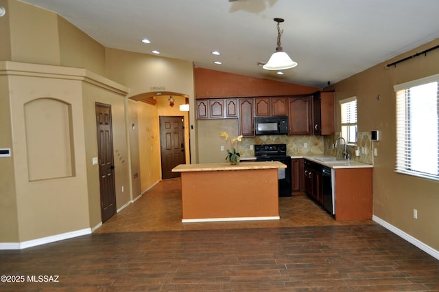 kitchen with lofted ceiling, light countertops, a sink, a center island, and black appliances