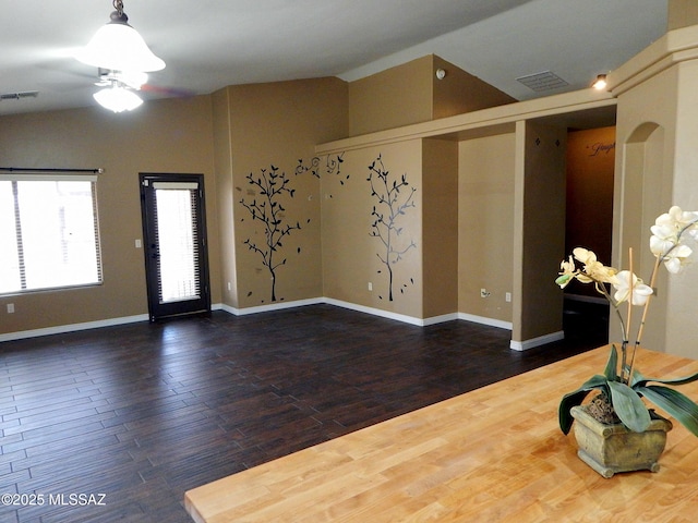 interior space with lofted ceiling, wood finished floors, visible vents, and ceiling fan