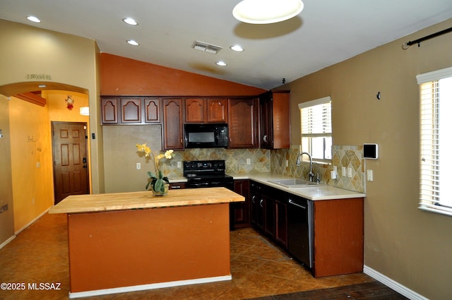 kitchen with decorative backsplash, arched walkways, a sink, and black appliances