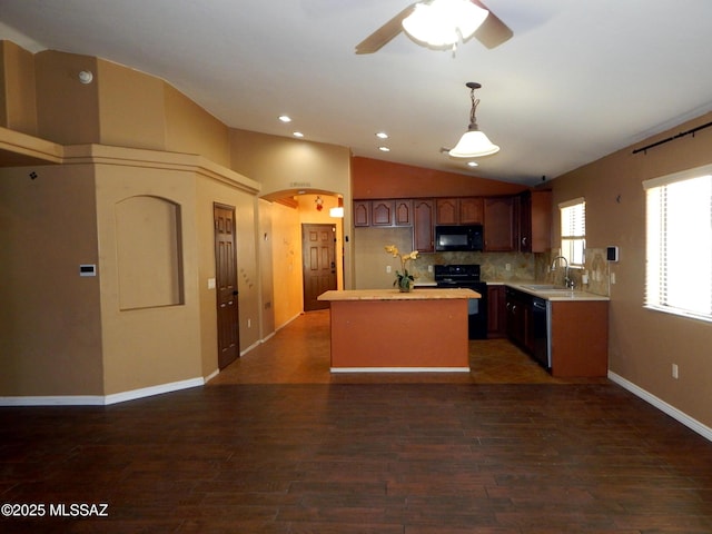 kitchen featuring lofted ceiling, light countertops, a sink, a center island, and black appliances