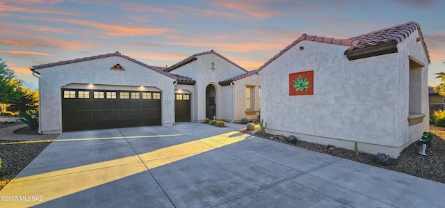 mediterranean / spanish-style house with a garage