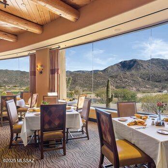 dining area with a mountain view, beam ceiling, and wooden ceiling