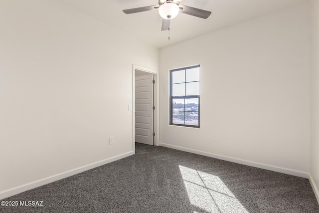 spare room featuring ceiling fan and dark carpet