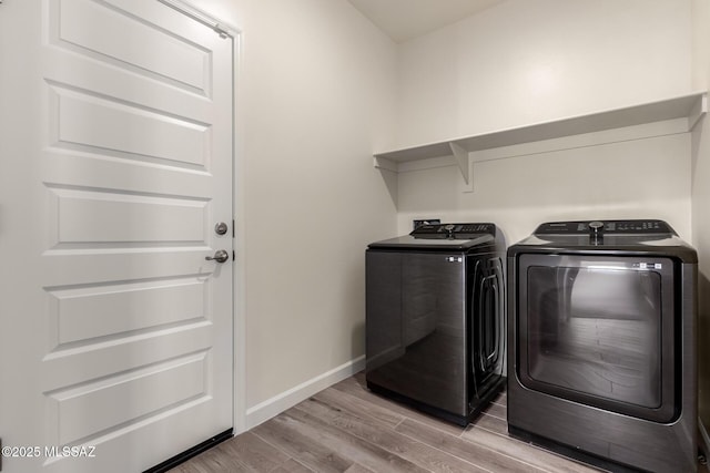 laundry area featuring washer and dryer and light hardwood / wood-style floors