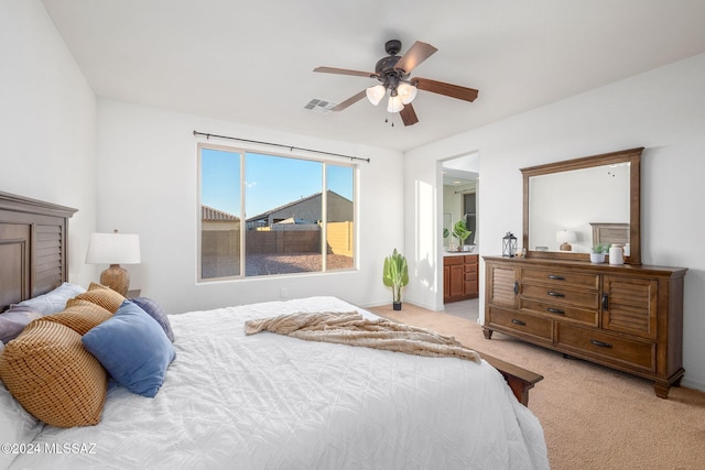 bedroom with light carpet, ceiling fan, and ensuite bathroom