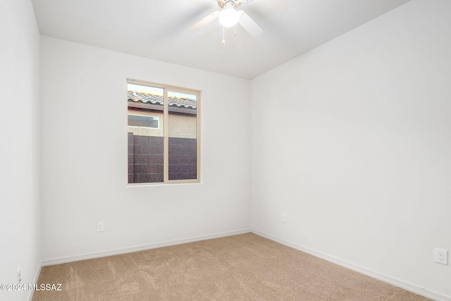 spare room featuring light colored carpet and ceiling fan