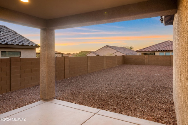 yard at dusk featuring a patio area