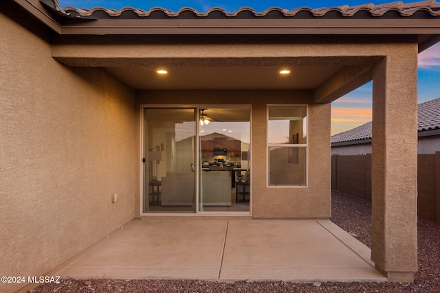 exterior entry at dusk with a patio area