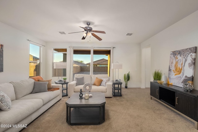 carpeted living room with ceiling fan