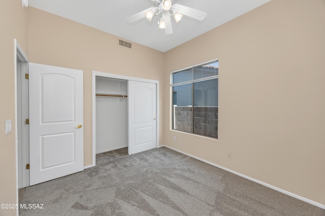 unfurnished bedroom featuring light colored carpet, a closet, and ceiling fan