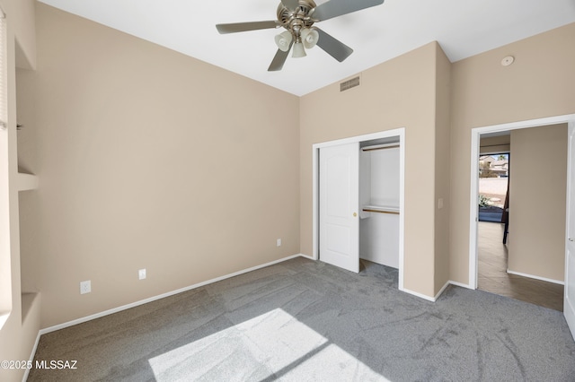 unfurnished bedroom featuring carpet floors, a closet, and ceiling fan