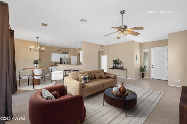 tiled living room featuring ceiling fan with notable chandelier