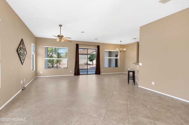 tiled empty room with ceiling fan with notable chandelier