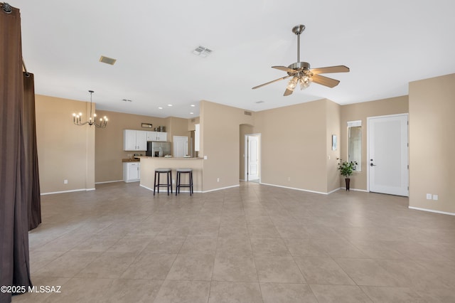 unfurnished living room with light tile patterned flooring and ceiling fan with notable chandelier