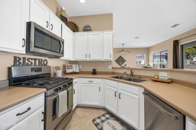 kitchen with white cabinetry, sink, light tile patterned floors, ceiling fan, and stainless steel appliances