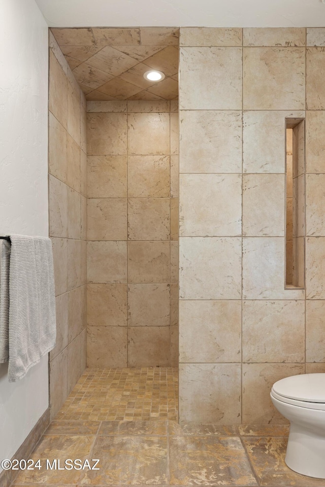 bathroom featuring toilet and tiled shower