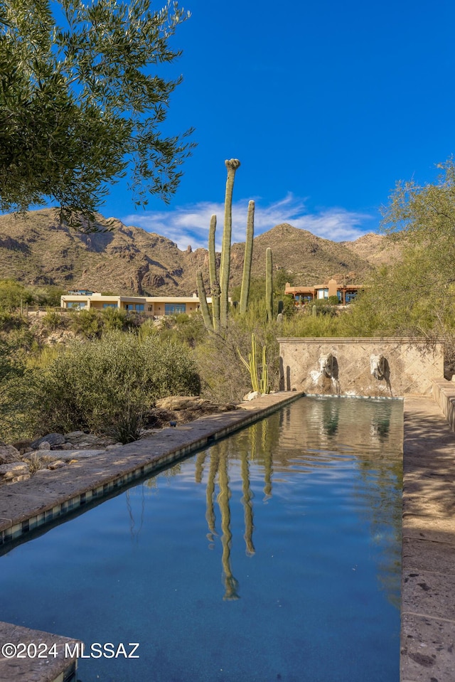 view of pool with a water and mountain view