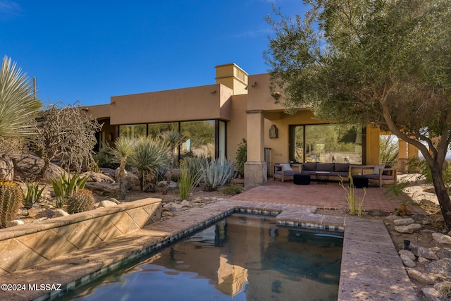 back of property featuring outdoor lounge area and a patio