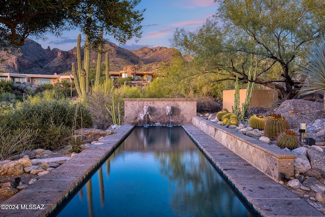 pool at dusk with a mountain view