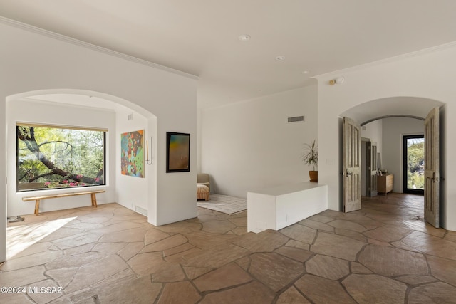 unfurnished room with crown molding and a healthy amount of sunlight