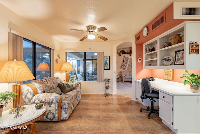 office with built in desk and ceiling fan