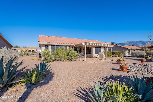 back of house with a mountain view, a pergola, and a patio