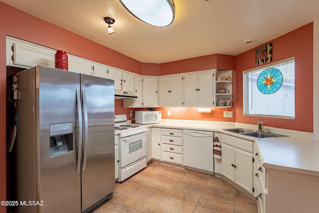 kitchen with white cabinetry, sink, white appliances, and a textured ceiling