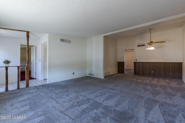 unfurnished room featuring light carpet, ceiling fan, and a textured ceiling