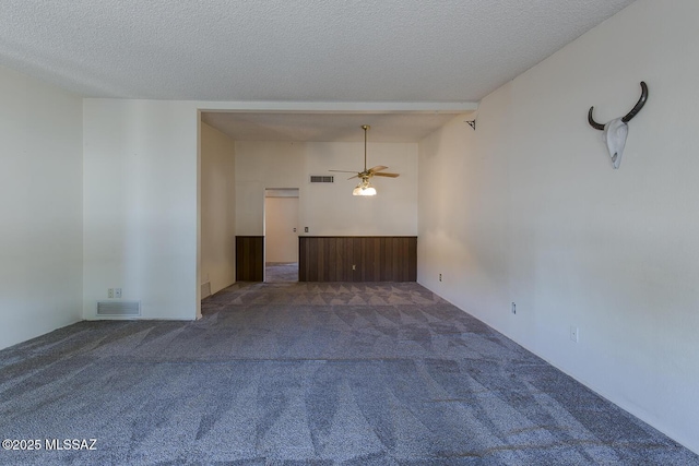 empty room featuring ceiling fan, carpet floors, and a textured ceiling