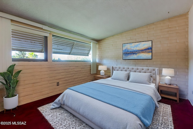 bedroom with lofted ceiling and a textured ceiling