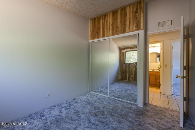 bedroom featuring carpet, a closet, and a textured ceiling