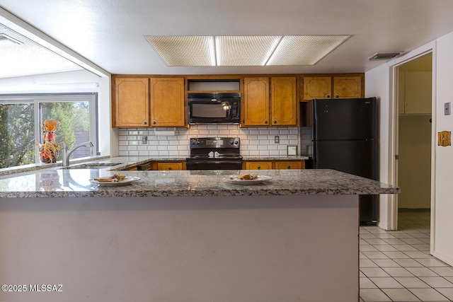 kitchen featuring light tile patterned flooring, black appliances, sink, backsplash, and kitchen peninsula