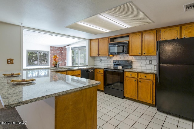 kitchen featuring tasteful backsplash, black appliances, sink, light tile patterned floors, and kitchen peninsula