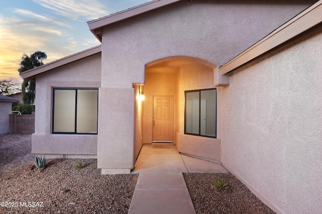 exterior entry at dusk with stucco siding