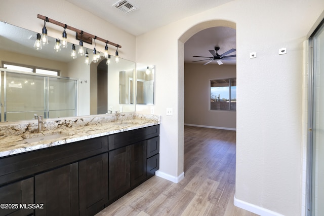 bathroom with hardwood / wood-style flooring, ceiling fan, vanity, and a shower with shower door