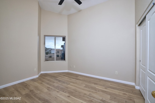 unfurnished bedroom with light wood-type flooring, baseboards, and ceiling fan