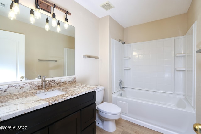 bathroom featuring toilet, vanity, visible vents, and wood finished floors