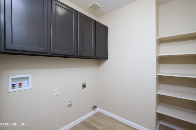 laundry room with gas dryer hookup, cabinets, washer hookup, hookup for an electric dryer, and light wood-type flooring