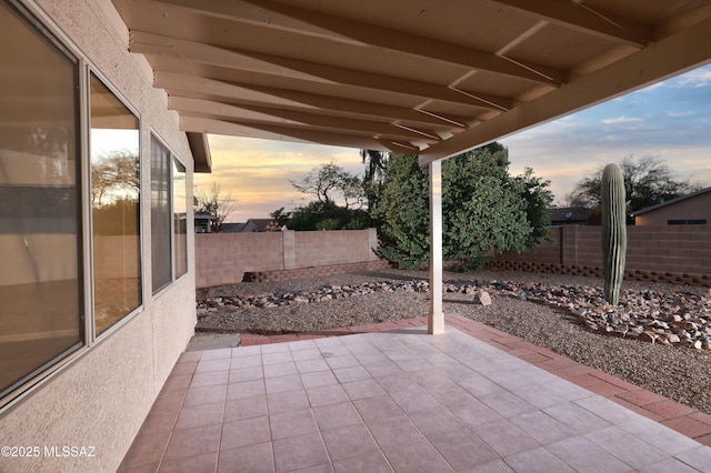 patio terrace at dusk with a fenced backyard